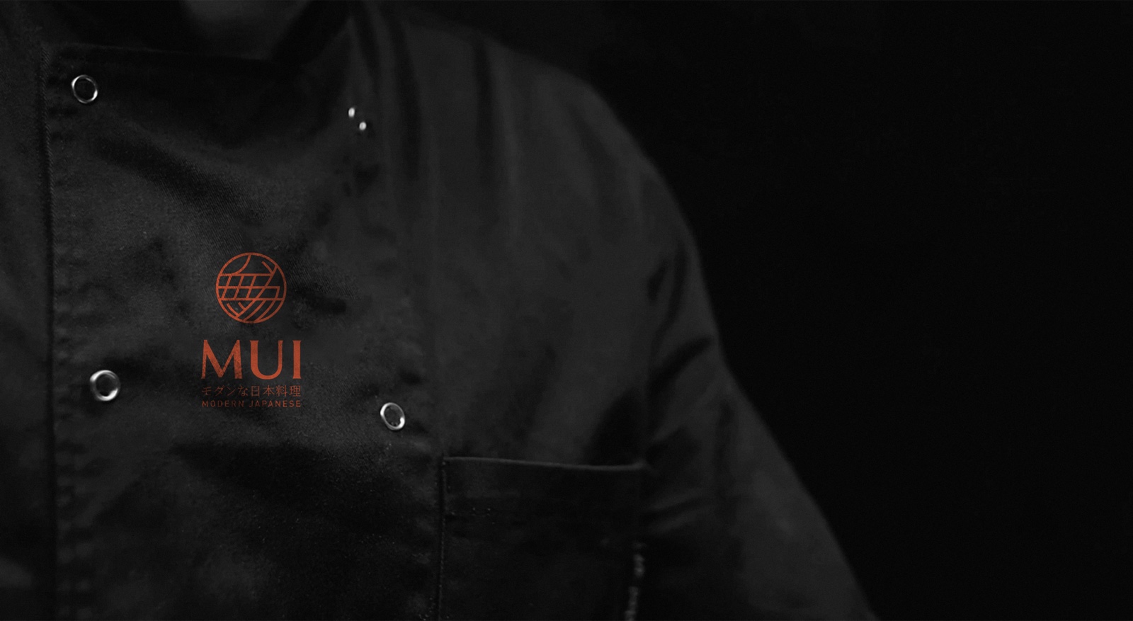 MUI's chef in a black jacket embroidered with the MUI crest, photographed without showing his face