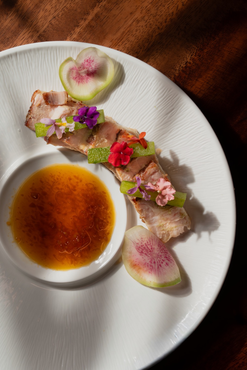 Pork belly with watermelon radish, edible flowers and ginger citrus sauce
