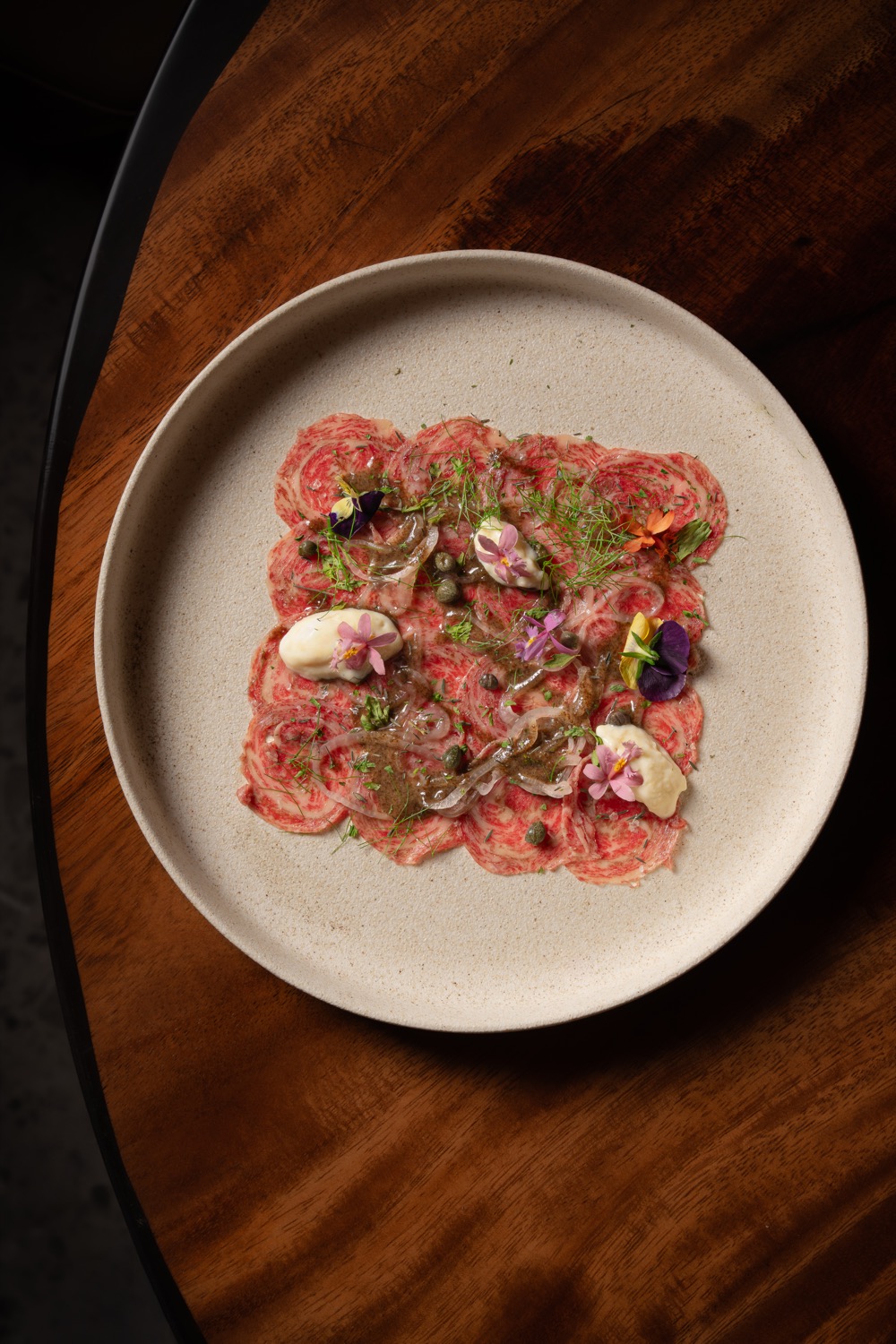 Wagyu carpaccio with capers, herbs, aioli and edible flowers